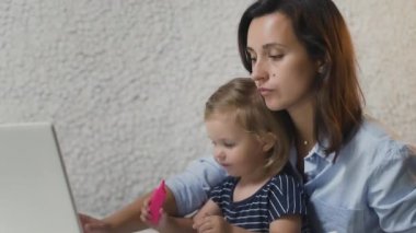 Küçük çocukla evden çalışan genç bir kadın. Mutlu anne.