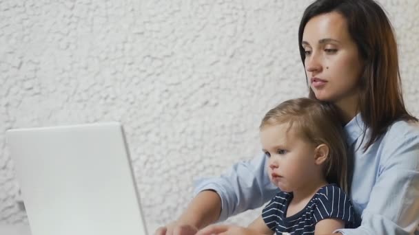 Mujer de negocios ocupada trabajando con el bebé en el regazo — Vídeos de Stock