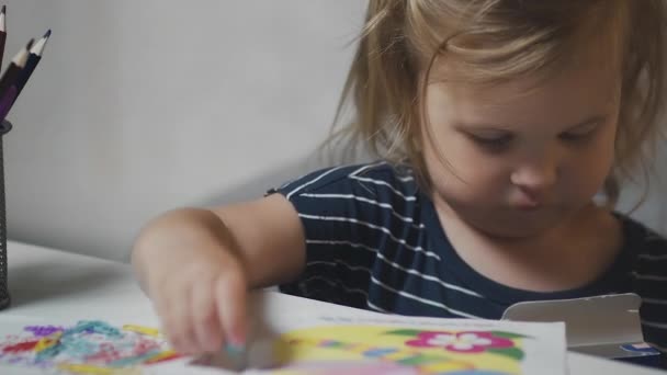 Detailní záběr malé holčičky dwaring a hrát si s klipy — Stock video