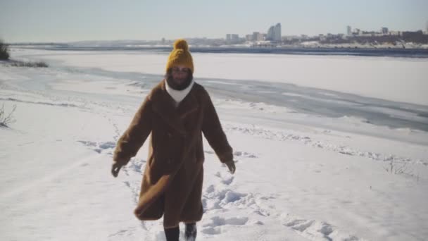 Молода жінка в хутрі ходить уздовж зимового пляжу. — стокове відео