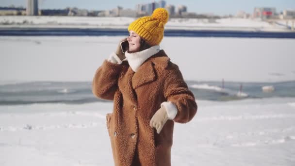 Jeune femme en manteau de fourrure parle au téléphone — Video