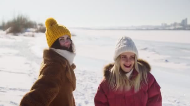 Två kvinnor vänner har kul i vinter park — Stockvideo