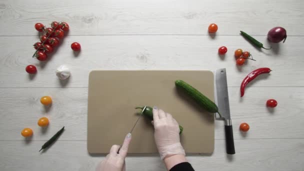 Chef κόβει αγγούρια σε πλαστικό πίνακα πάνω όψη — Αρχείο Βίντεο