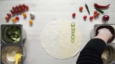 Şefin beyaz eldivenli elleri, domatesleri pide ya da lavda kebap kebabına koyuyor. Tavuk, patates kızartması, peynir ve sebzeli shawarma pişiriyorum.