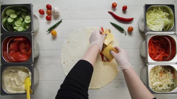 Top view of chef hands in white gloves puts cabbage on doner kebab shawarma in pita or lavash. Shawarma with chicken cutlet, pappers, cheese and vegetable — Stock Video