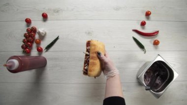 Profesyonel şef fast food restoranında lezzetli bir sandviç pişiriyor..