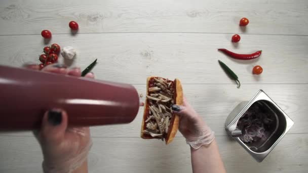 顶级专业厨师在快餐店烹调美味三明治.戴手套的女厨师在三明治里放bbq酱汁 — 图库视频影像