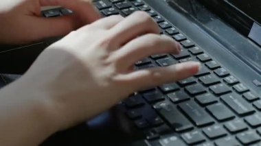 Dizüstü bilgisayara mesaj yazan bir kadın. Siyah bir dizüstü bilgisayarda daktilo sürecinin kapatılması.