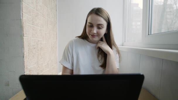 Estudiante joven aprendiendo y estudiando en casa en interiores. Chica modelo femenina independiente trabajando fuera de la oficina . — Vídeo de stock