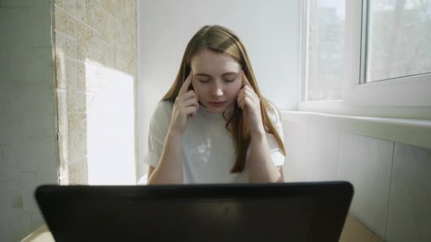 Κοντινό πλάνο πορτρέτο της κουρασμένης επιχειρηματία που εργάζονται στο φορητό υπολογιστή στο σπίτι με φρικτό πόνο στο κεφάλι κατά το χρόνο εργασίας. — Αρχείο Βίντεο
