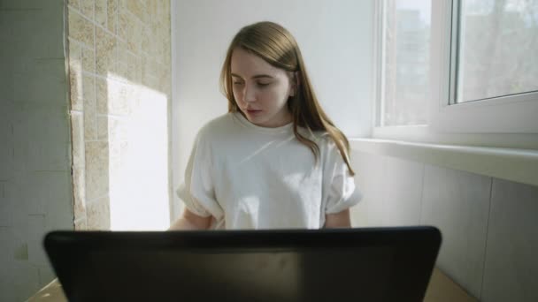 Frau telefoniert und arbeitet von zu Hause aus am Laptop wegen Selbstisolation mit Coronavirus. Authentischer Arbeitsplatz zu Hause. Handschuss mit Gimbal. Coronavirus-Ausbruch 2020. — Stockvideo