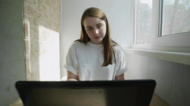 Coronavirus 'un kendi kendini izole etmesi nedeniyle laptopta çalışan bir kadın sesli mesaj kaydediyor. Otantik ev işyeri. El kamerasıyla, el kamerasıyla. Coronavirüs salgını 2020.