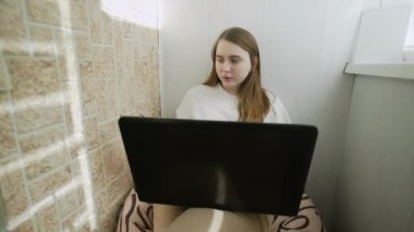 Kadın telefonla konuşuyor ve Coronavirus 'un kendi kendini izole etmesi yüzünden bilgisayarla evden çalışıyor. Özgün ev işyeri.
