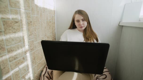 Mulher bonita nova trabalha em um computador portátil em casa. isolamento escritório vírus Corona . — Vídeo de Stock