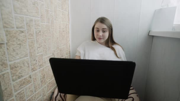 Jovem mulher sentada na varanda, trabalhar em freelance, usando laptop. Focado menina usar computador para estudo on-line, usuário do sexo feminino ocupado no trabalho à distância na internet em casa — Vídeo de Stock