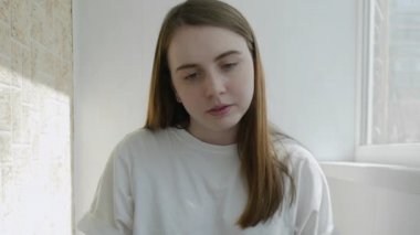 Genç kadın bugün işini bitirdi, dizüstü bilgisayarını kapatıp esneme hareketleri yapıyor. Otantik ev işyeri. El kamerasıyla, el kamerasıyla. Coronavirüs salgını 2020.