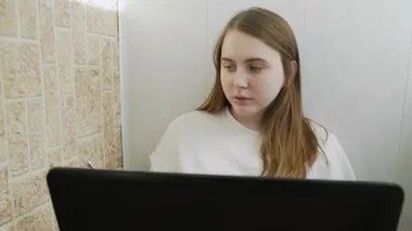 Kadın telefonla konuşuyor ve Coronavirus 'un kendi kendini izole etmesi yüzünden bilgisayarla evden çalışıyor. Özgün ev işyeri.