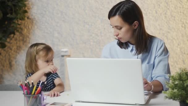 Multitarea madre trabajando en la oficina con la niña — Vídeos de Stock