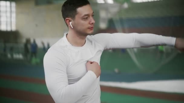 Young male boxer with wireless headphone warm up before sports exercise — Stock Video