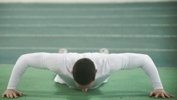 Jongeman doet push-ups in het groene stadion. Close-up van de sporter tijdens de ochtendtraining. Gezond levensstijl concept — Stockvideo