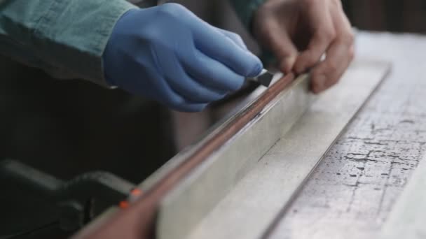 Aplicando tinte de borde negro al cuero. Proceso de trabajo del cinturón de cuero en el taller de cuero . — Vídeos de Stock