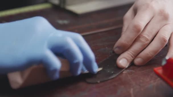 Le tanneur professionnel aiguise une ceinture. Le maître du cuir fait une ceinture — Video