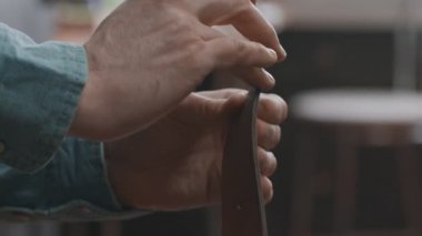 Profesyonel bronzlaştırıcıyı kapat ve atölyede kemerine yapıştırıcı sür. Deri atölyedeki deri kemerin çalışma süreci..