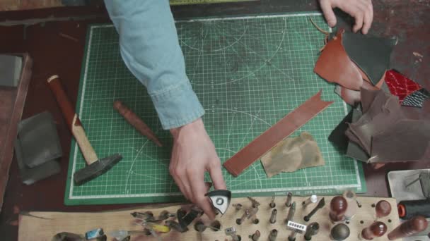 Primer plano del proceso de costura de cuero. Manos con aguja y cuerdas haciendo billetera en taller. Proceso de fabricación de billetera de cuero hecha a mano. Artículos de cuero hechos a mano en cámara lenta . — Vídeo de stock