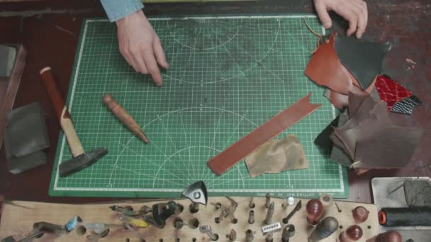 Вид сверху столешницы в кожаной мастерской с различными инструментами — стоковое видео