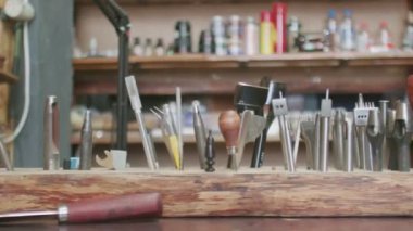 Tanner aletleri ahşap stantta. Deri atölyesinde çalışma süreci.