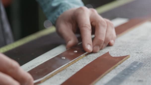 Pracovní proces koženého opasku v kožené dílně. Muž držící řemeslný nástroj a pracující. Tanner ve staré koželužně. — Stock video