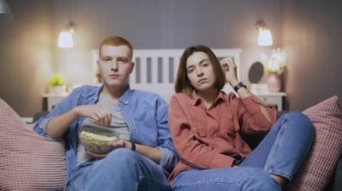 Genç, yakışıklı beyaz bir adam ve kız TV 'de ilginç bir film izliyorlar. Kanepedeki karanlık salonda patlamış mısırla birlikte. Karantina, salgın hastalık, virüs. Evde kal.