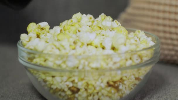 Vrouwelijke hand plukken popcorn van papier emmer close-up. Close-up van een vrouw die popcorn eet in de bioscoop. Movie food concept. Vrouwelijke hand nemen popcorn. — Stockvideo