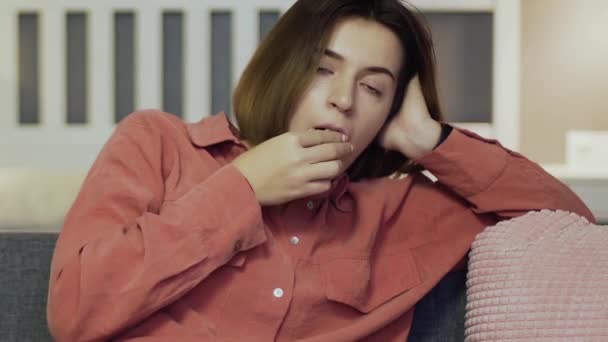 Mujer aburrida sentada en el sofá, comiendo palomitas de maíz y viendo la televisión — Vídeo de stock