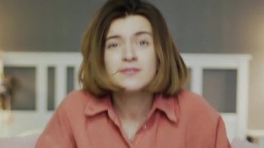 Kanepede oturup patlamış mısır yiyen, futbol maçı izleyen heyecanlı bir kadın.