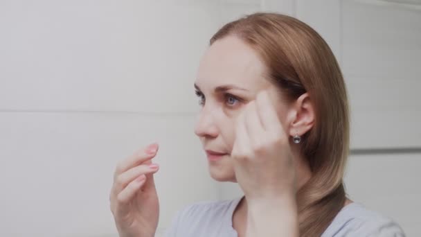 Close de mulher adulta remove remendos na área sob os olhos . — Vídeo de Stock