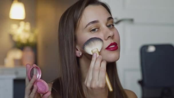 Primer plano de la mujer hermosa uso cepillo mientras que la revisión de maquillaje tutorial de difusión de vídeo en vivo a la red social por Internet . — Vídeo de stock