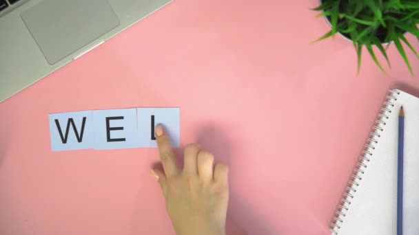 Top view time lapse letters cards leżące na różowym biurku. Słowo WELCOME — Wideo stockowe