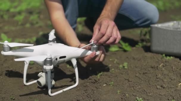 Drone pilot instal propeller on his white drone outdoors — Stock Video