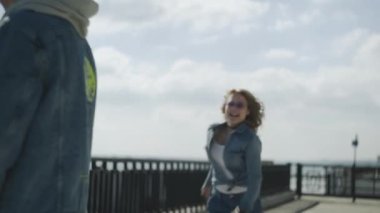 Genç kadın erkeklere doğru koşar ve onun sırtına atlar.