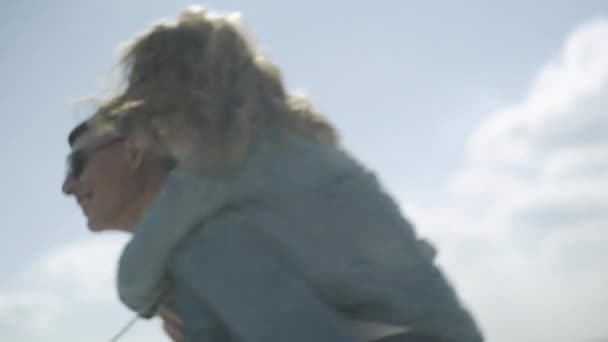 Közelkép a fiatal férfi viszi a hátán egy nő, és élvezi — Stock videók
