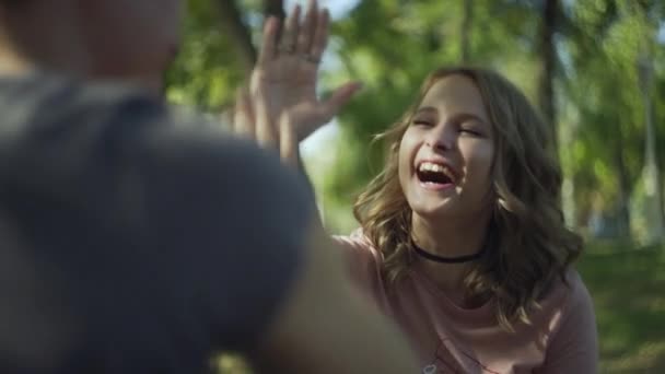 Jeune homme et femme donnant un cinq dans le parc — Video