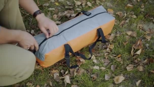 Mann öffnet Tasche mit Zelt im Wald — Stockvideo