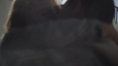 Genç kaygısız çift birbirine sarılıyor ve öpüşüyor.