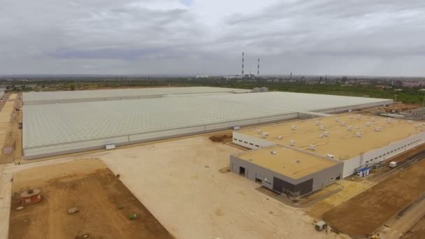 Überfliegen eines großen Gebäudes Gewächshäuser für den Anbau von Gemüse, ein Gewächshaus mit einem transparenten Dach, ein Gewächshaus Blick von oben. — Stockvideo