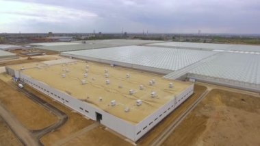 Sebze yetiştirmek için büyük bir binanın üzerinde uçmak şeffaf çatılı bir sera, yukarıdan manzaralı bir sera..