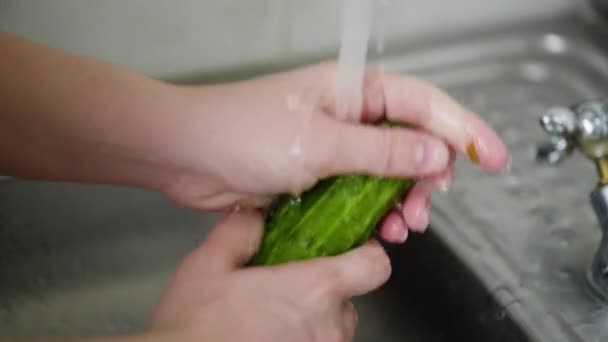 Крупним планом кухарка миє свіжий огірок — стокове відео