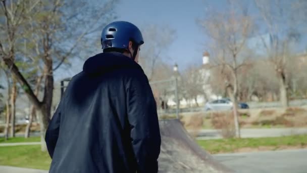 Mladý bmx jezdec opouští extrémní park, mává rukou a loučí se se svými přáteli — Stock video