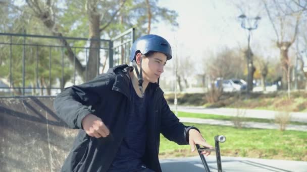 Un giovane cavaliere bmx seduto su una moto e parlare sulla spartphone — Video Stock