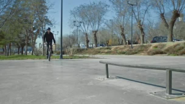 Молодой байкер делает трюки на трубе в скейт-парке. . — стоковое видео